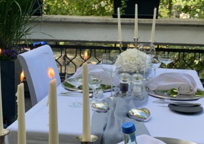 Nahaufnahme brennender Stabkerzen auf der Terrasse des Wirtshaus Alpinia bei einem Candlelight-Dinner