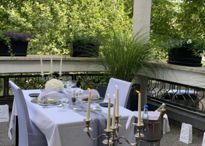 Silberner Kerzenleuchter auf einem festlich eingedeckten Tisch für zwei auf der Terrasse des Wirtshaus Alpinia
