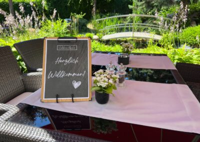 Herzlich-Willkommen-Schild an der Gartenbrücke im Wirtshaus Alpinia