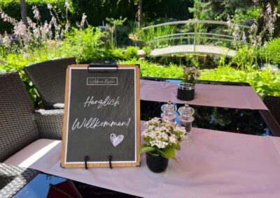Herzlich-Willkommen-Schild auf dem Terrassentisch im Wirtshaus Alpinia
